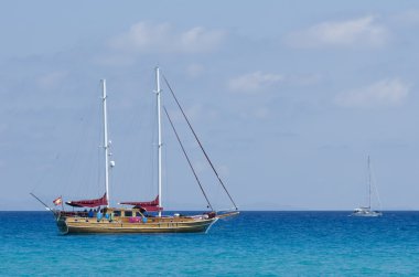 Üzerinde mavi bir deniz demirleyen gemi yelken
