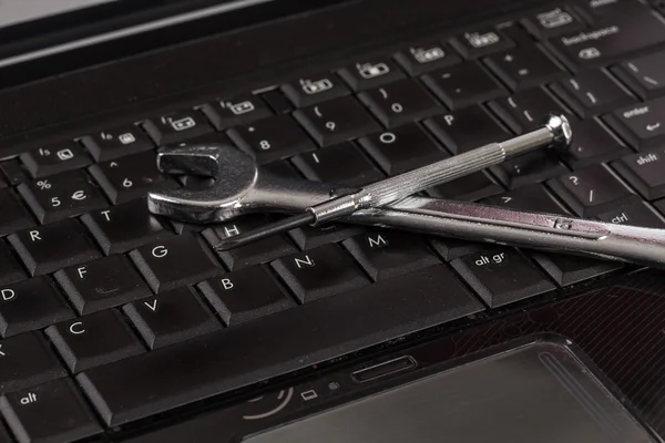 Гаечный ключ и отвертки на ноутбуке — стоковое фото