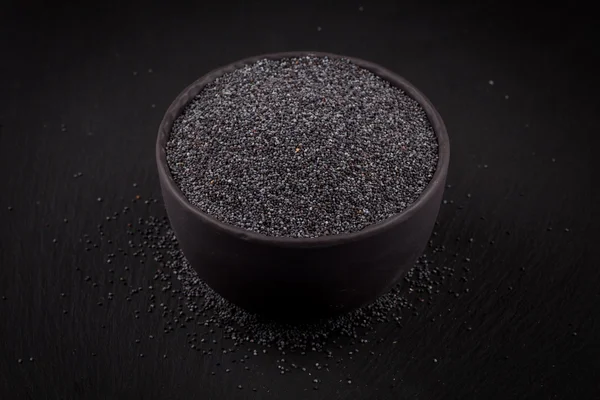 Poppy seeds in a stone bowl — Stock Photo, Image