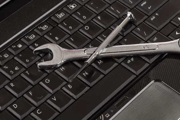 Гаечный ключ и отвертки на ноутбуке — стоковое фото