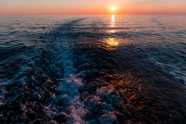 Puesta del sol del mar con rastro del barco — Foto de Stock