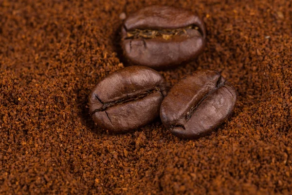 Coffee beans on heap of ground — Stock Photo, Image
