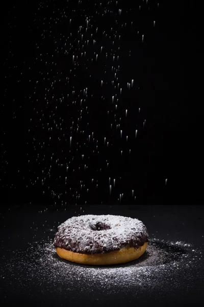 Порошок сахара на шоколадный пончик — стоковое фото