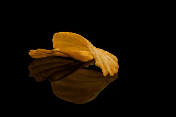 Potato chip on black surface — Stock Photo, Image