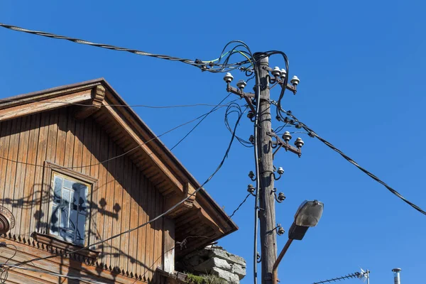青い空と古い家の上の電柱上の古い線 — ストック写真