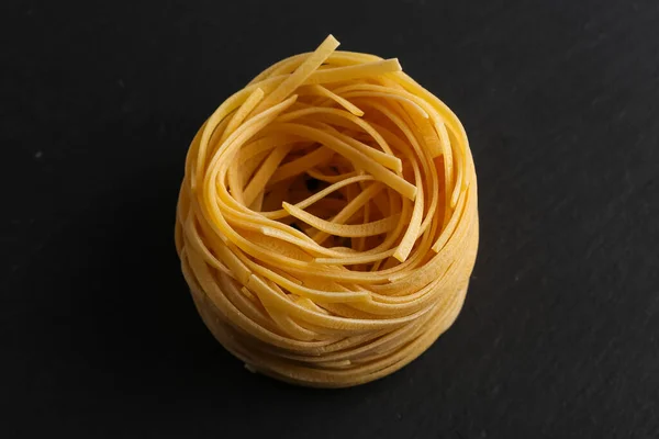 Fettuccine Pasta Nest Auf Schwarzem Stein Hintergrund — Stockfoto