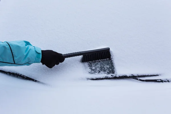 Mujer limpiando nieve del coche — Foto de Stock