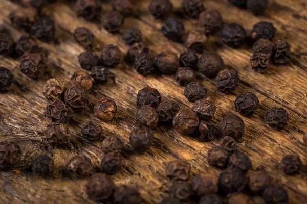 Pimenta preta na mesa de madeira — Fotografia de Stock