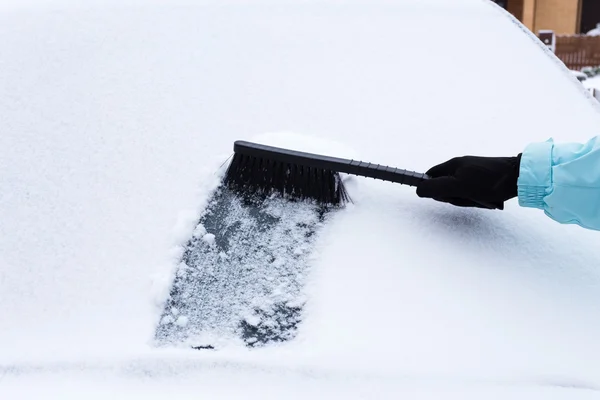Mujer limpiando nieve del coche — Foto de Stock