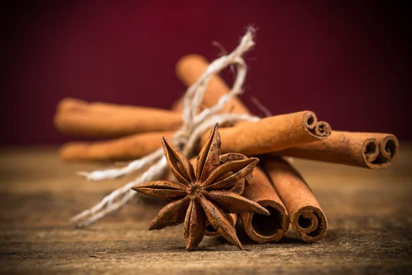 Close up of cinnamon sticks and star anise on wood — Stock Photo, Image