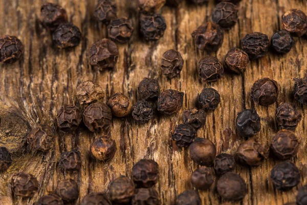 Black pepper on wooden table — Stock Photo, Image