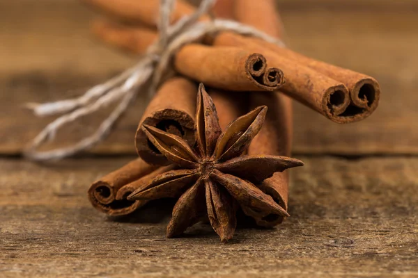 Close up of cinnamon sticks and star anise on wood — Stock Photo, Image