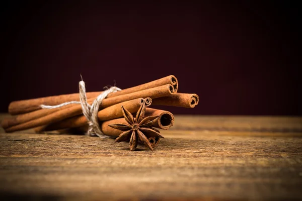 Close up of cinnamon sticks and star anise on wood — Stock Photo, Image