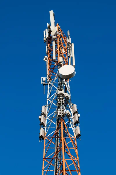 Communications tower with antennas on blue sky — Stock Photo, Image