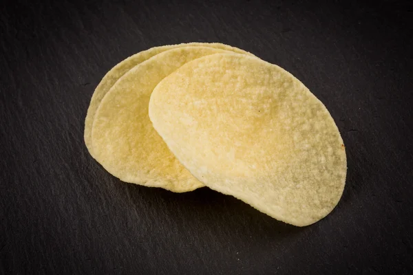 Potato chips on a black background — Stock Photo, Image