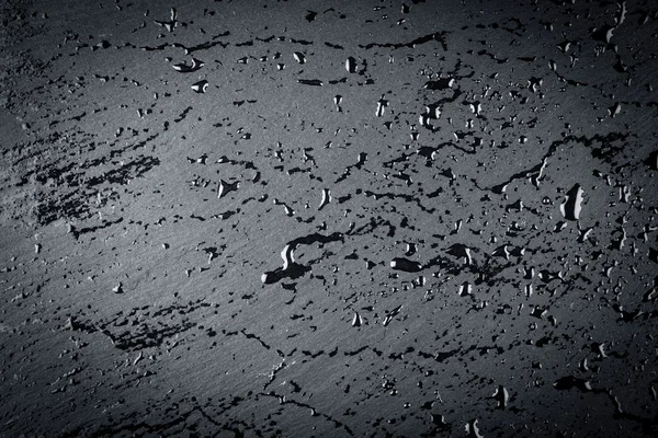 Вода на поверхности темного камня — стоковое фото