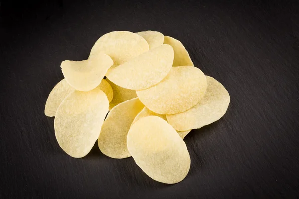 Potato chips on a black background — Stock Photo, Image