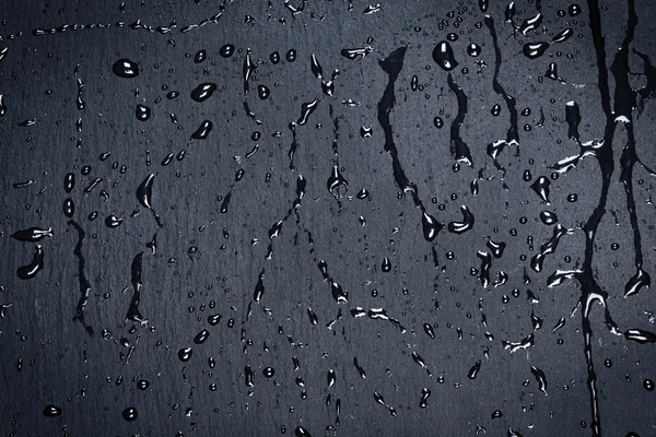 Agua en la superficie de piedra oscura — Foto de Stock