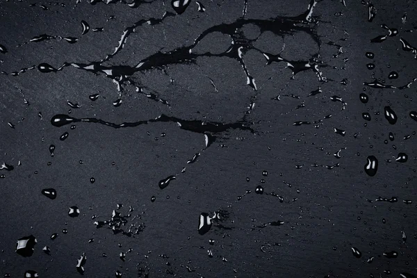 Agua en la superficie de piedra oscura — Foto de Stock