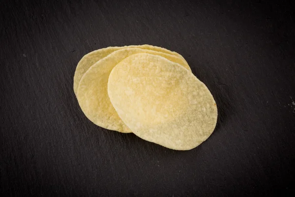 Potato chips on a black background — Stock Photo, Image