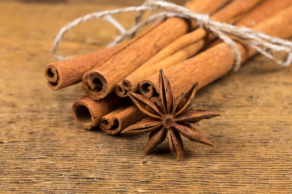 Close up of cinnamon sticks and star anise on wood — Stock Photo, Image