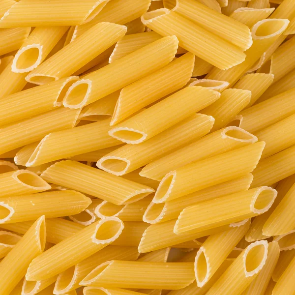 Dried penne pasta background — Stock Photo, Image