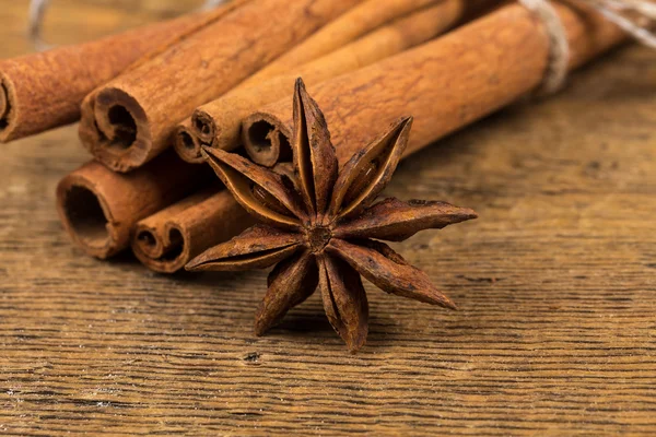 Close up of cinnamon sticks and star anise on wood — Stock Photo, Image