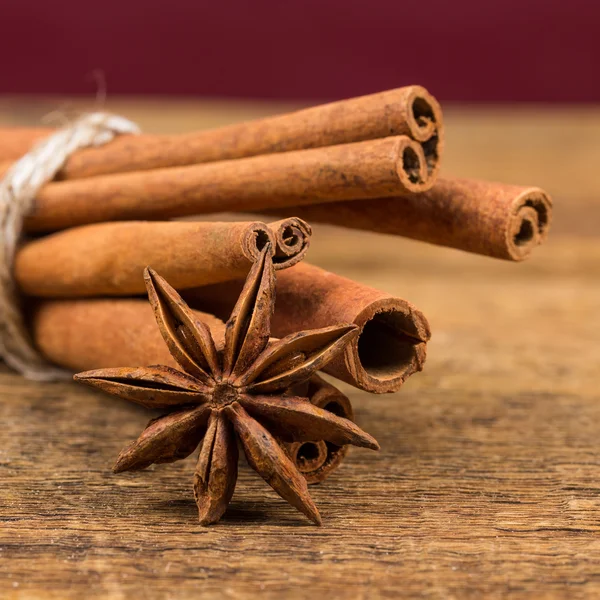 Close up of cinnamon sticks and star anise on wood — Stock Photo, Image