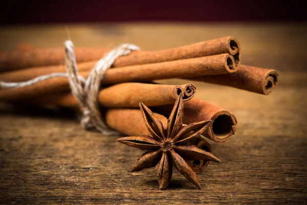 Close up of cinnamon sticks and star anise on wood — Stock Photo, Image