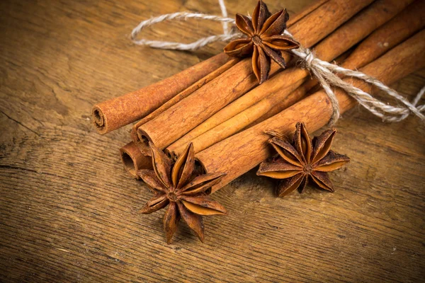 Close up of cinnamon sticks and star anise on wood — Stock Photo, Image