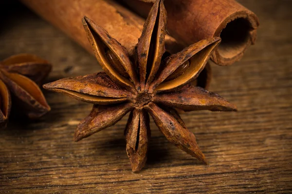 Close up of cinnamon sticks and star anise on wood — Stock Photo, Image