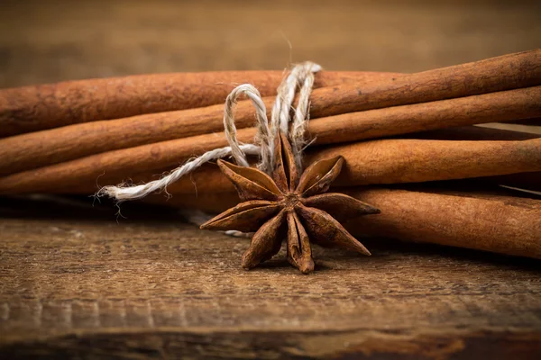 Close up of cinnamon sticks and star anise on wood — Stock Photo, Image