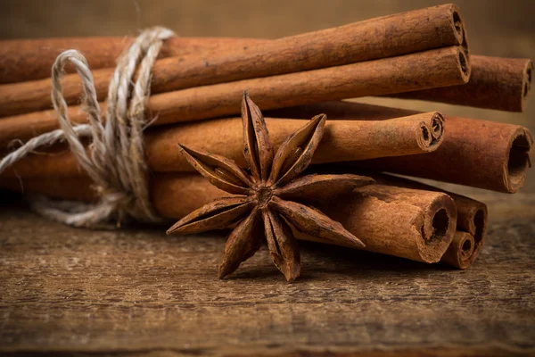 Close up of cinnamon sticks and star anise on wood — Stock Photo, Image