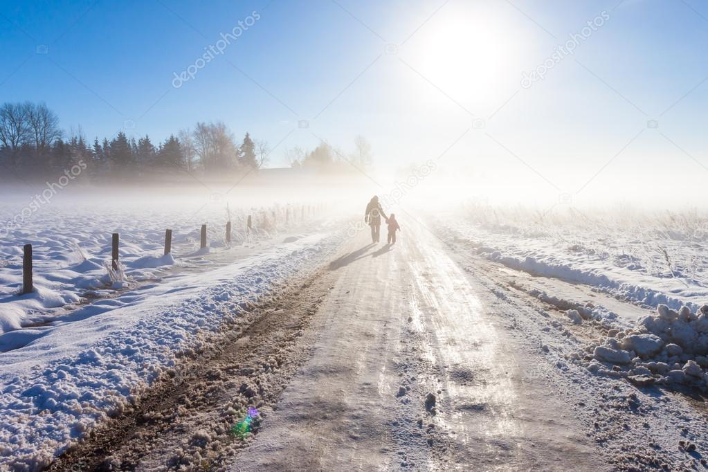 Mother and child on foggy snow road