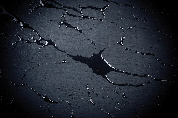 Agua en la superficie de piedra oscura — Foto de Stock