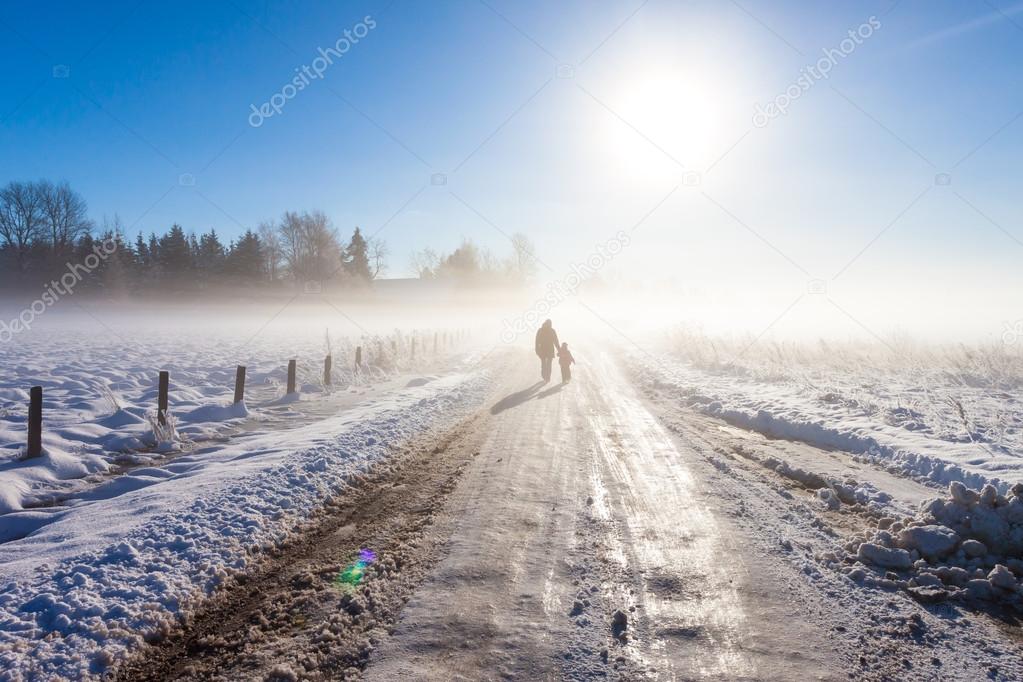 Mother and child on foggy snow road