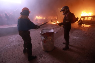 Protestocular varil üzerinde sopa beceriyor. Kiev, Ukrayna, Ocak 