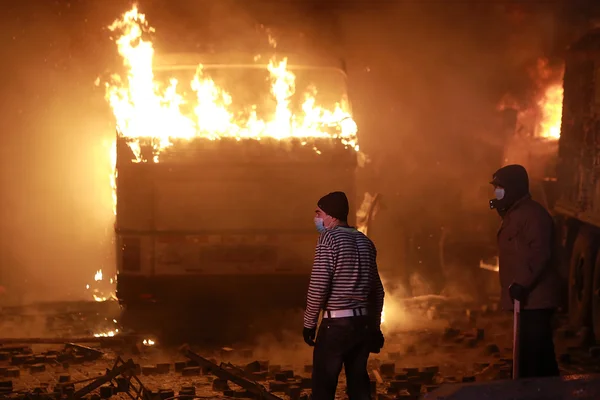 Mann im Hintergrund eines brennenden Busses. kyiv, ukraine, 1. januar — Stockfoto