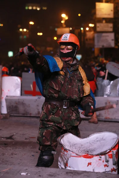 Agressieve protesteerder bangs zijn stok op het vat en toont een f — Stockfoto