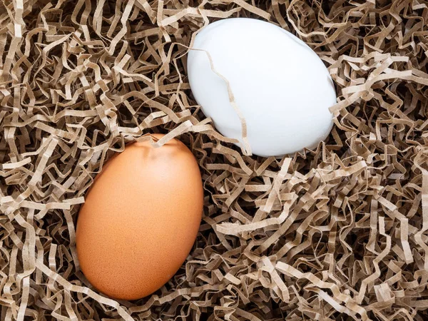 White and brown chicken eggs are in soft, paper, shockproof packaging, close-up, mock-up. Concept: Careful storage and delivery of fragile goods. Preparing eggs for painting and decorating at Easter.