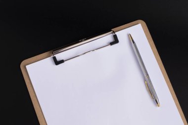 Siyah arka planda beyaz sayfa ve gümüş kalem. Boşluğu kopyala