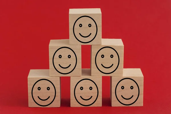 Uśmiechnięte Ikony Twarzy Drewnianych Kostkach Czerwonym Tle Ocena Usług Biznesowych — Zdjęcie stockowe