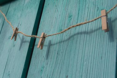 Ahşap bir arka planda ipte mandallar..