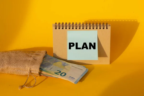 Słowo Plan Jest Napisane Niebieskiej Naklejce Banknoty Euro Żółtym Tle — Zdjęcie stockowe