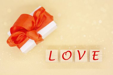 Tahta bloklara kırmızı saten kurdele ve aşk yazılı el işi hediye kutusu. Sevgililer günün kutlu olsun, doğum günün kutlu olsun, 8 Mart. Tatil konsepti