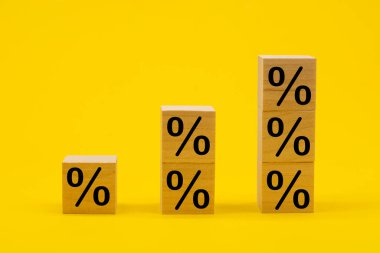 Tahta küplerdeki yüzde işareti sarı arka planda. İş ve finans indirimi veya faiz oranı kavramı.