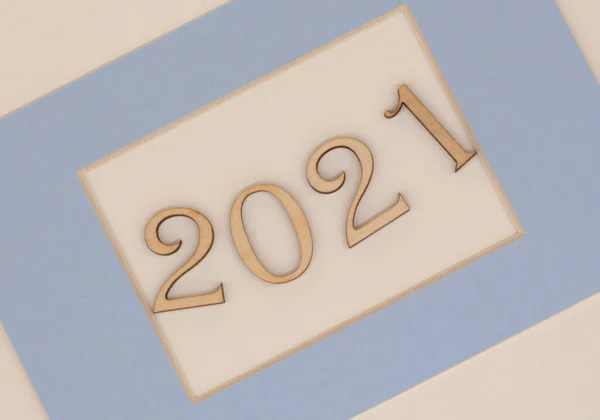 木製の番号は2021明るい背景の青い枠で 新年のコンセプト — ストック写真