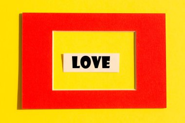 Sarı arka planda kırmızı çerçeveli aşk kelimesi. Sevgililer Günü