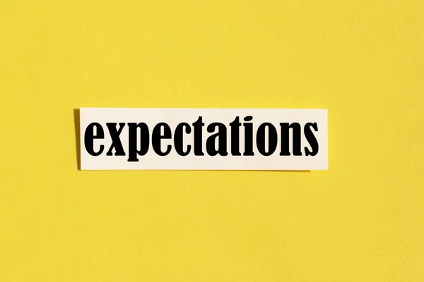 Ordet förväntningar på en gul bakgrund. Begreppet förväntningar — Stockfoto