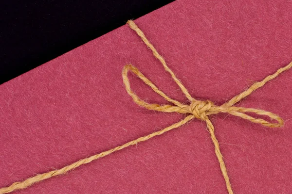 A gift envelope tied with string on a black background. Birthday